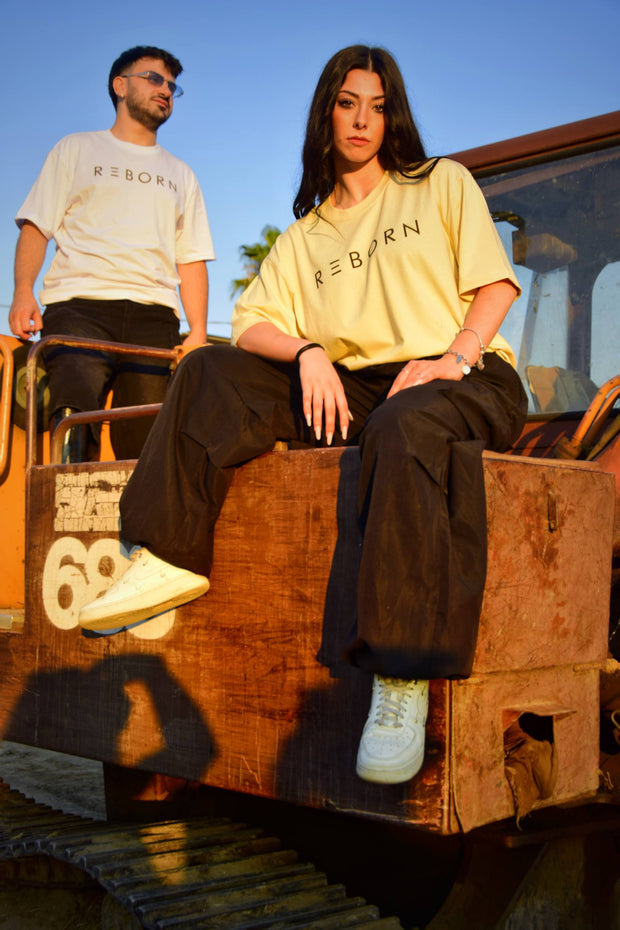 ragazza in primo piano e ragazzo sullo sfondo con indosso magliette del brand reborn
