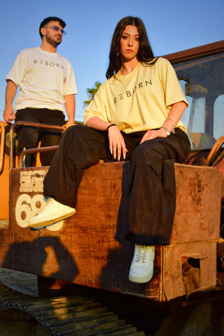 ragazza in primo piano e ragazzo sullo sfondo con indosso magliette del brand reborn