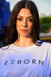 ragazza in primo piano con t-shirt reborn bianca con scritta nera