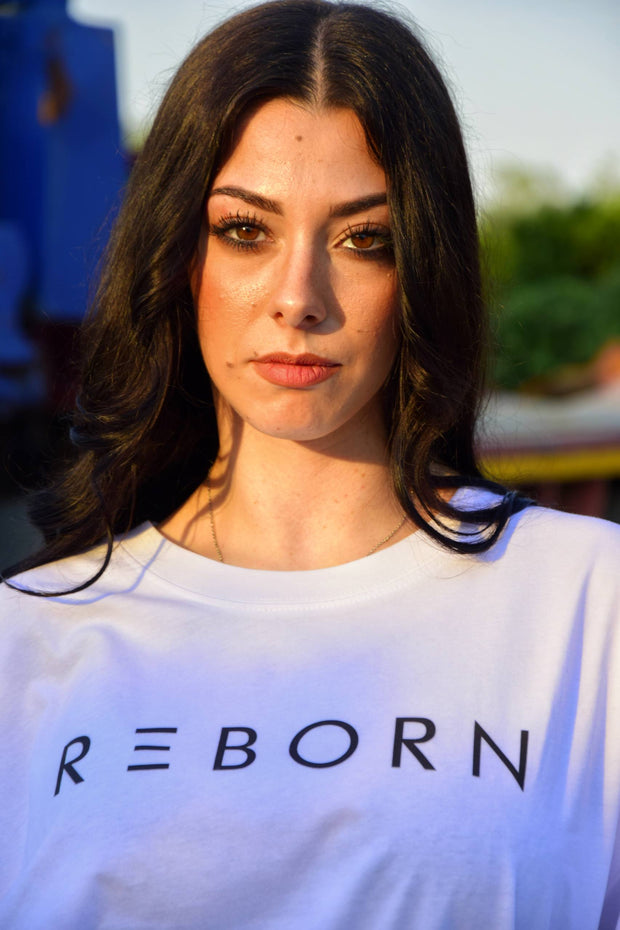 ragazza in primo piano con t-shirt reborn bianca con scritta nera