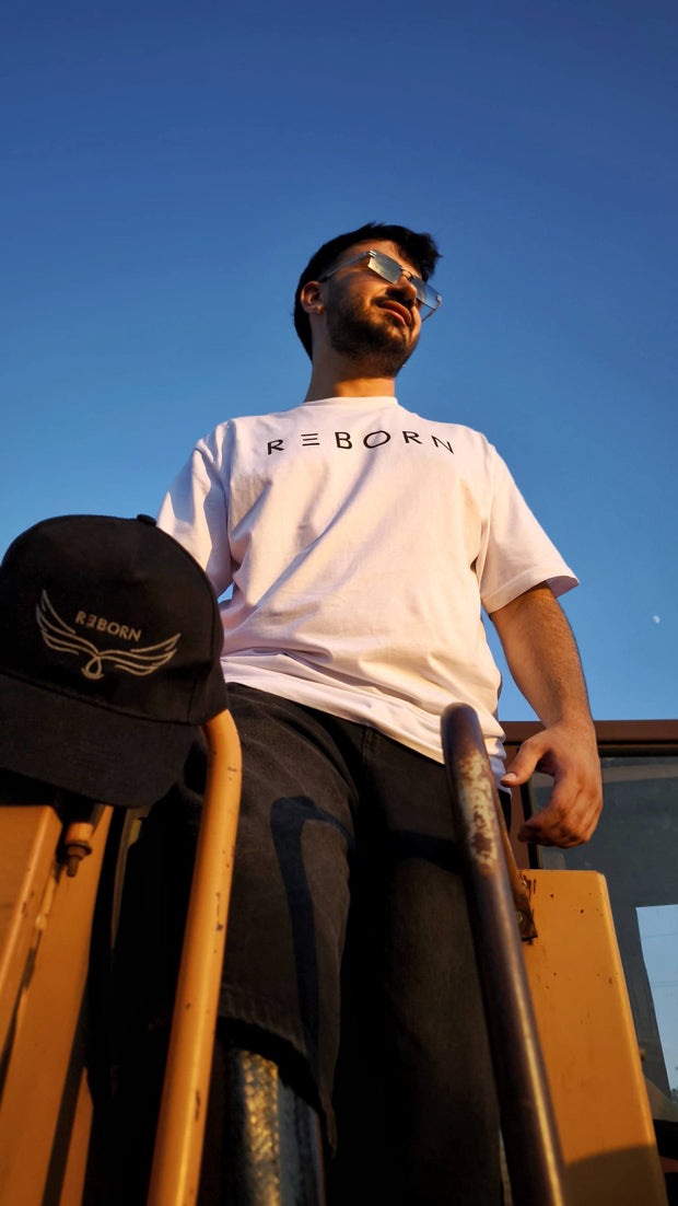t-shirt reborn bianca con scritta nera, ragazzo in piedi